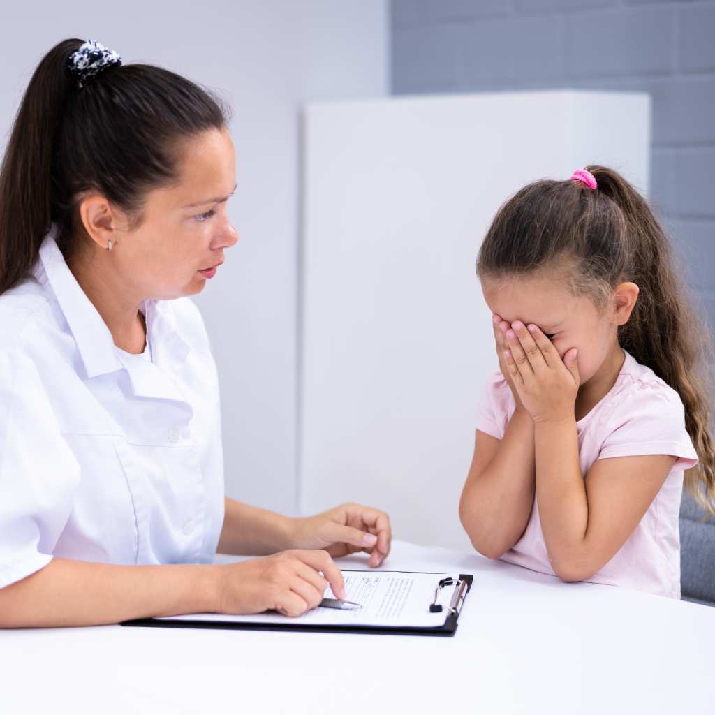 A therapist guiding a child with autism through challenging moments during a session