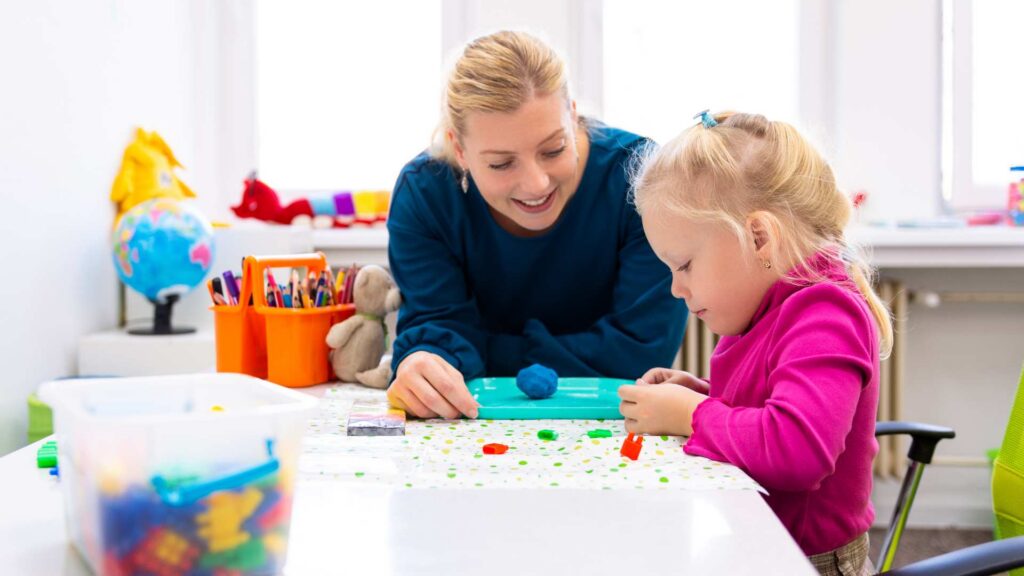 Adult supporting a young child during a playful learning activity to build soft skills in ABA