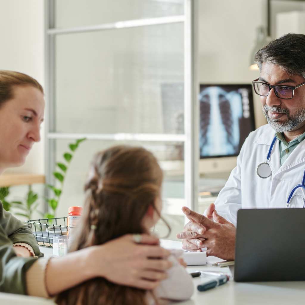 Clinician speaking with a parent and child during an autism assessment