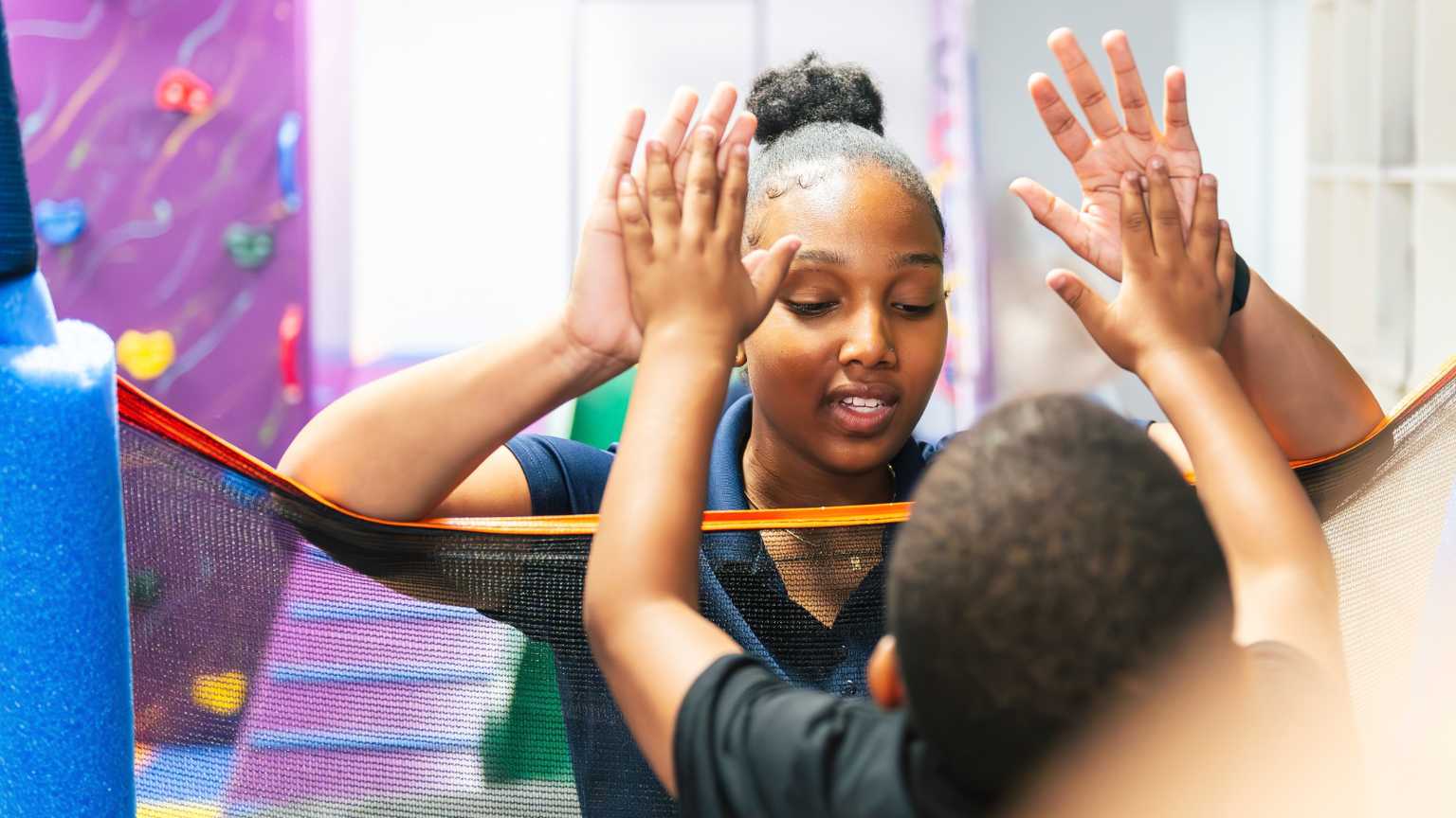 Early intervention for autism showing therapist encouraging child during ABA therapy activity